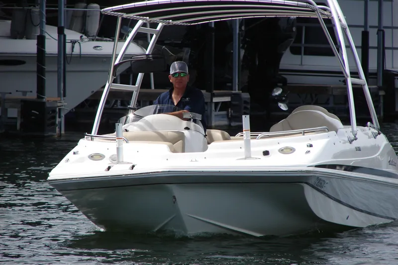 Slide: The Image of 2017 Hurricane SunDeck Sport 202 IO boat on water, with driver wearing sunglasses. - 8