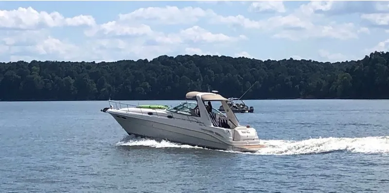 Slide: The Image of 1999 Sea Ray 340 Sundancer cruising on a calm lake. - 15