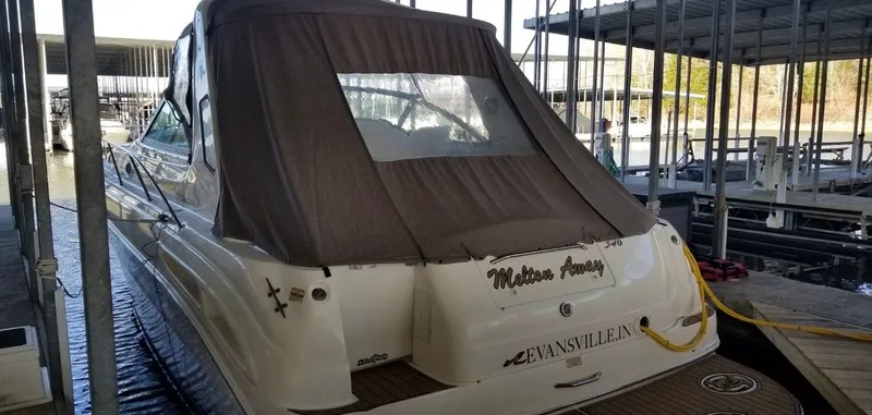 Slide: The Image of 1999 Sea Ray 340 Sundancer docked, featuring brown cover. - 24