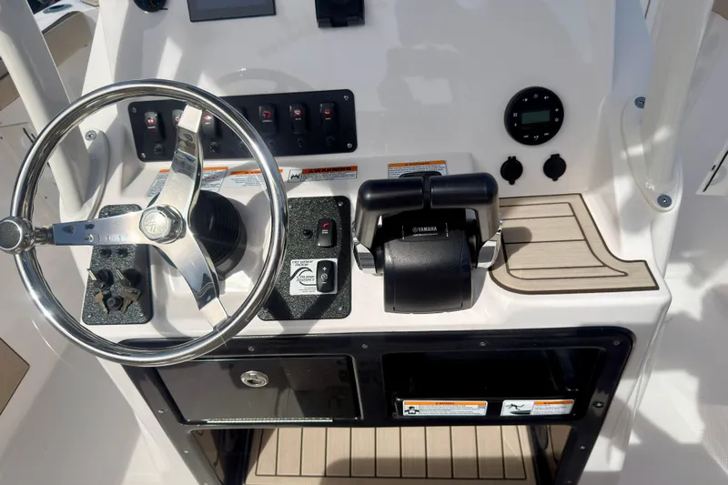 Slide: The Image of Control panel of 2025 Yamaha Boats 222 FSH Sport, featuring steering wheel and throttle controls. - 18