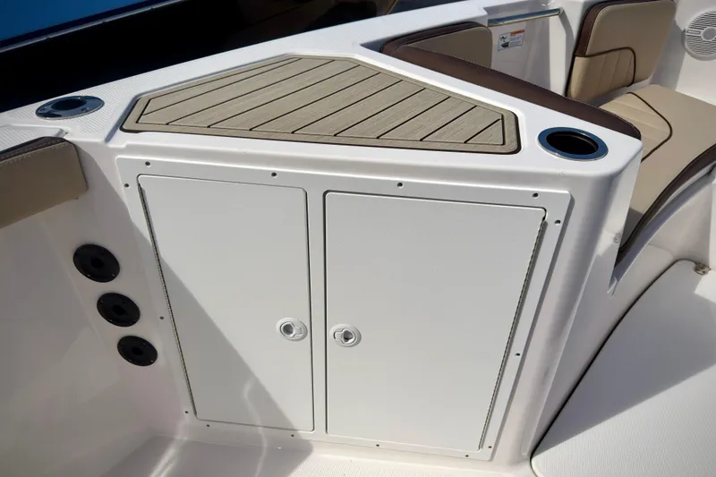 Slide: The Image of 2025 Yamaha Boats 222 FSH Sport interior with storage compartment and cup holders. - 19
