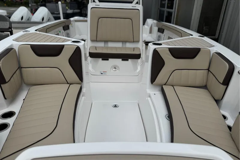 Slide: The Image of 2025 Yamaha Boats 222 FSH Sport interior with beige and brown seating, cup holders, and sleek design. - 2