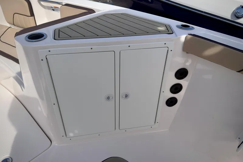 Slide: The Image of 2025 Yamaha Boats 222 FSH Sport interior with storage compartment and cup holders. - 20