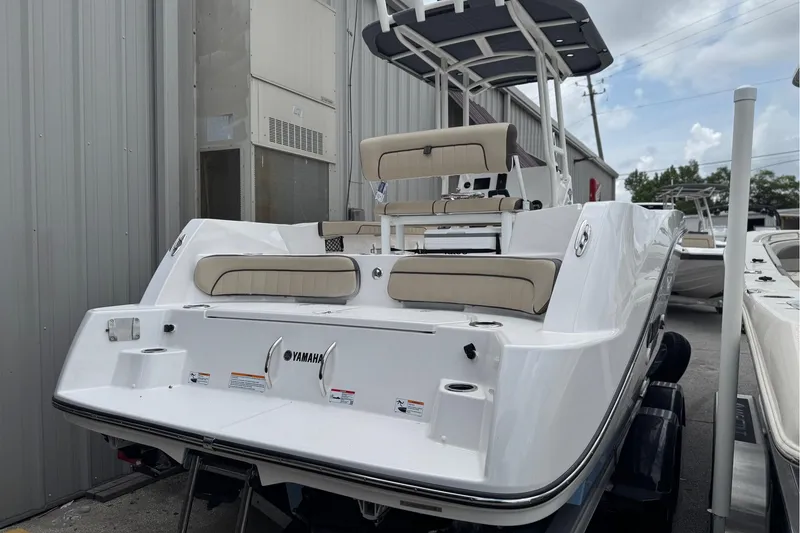 Slide: The Image of 2025 Yamaha Boats 222 FSH Sport, sleek white design, docked outdoors. - 4