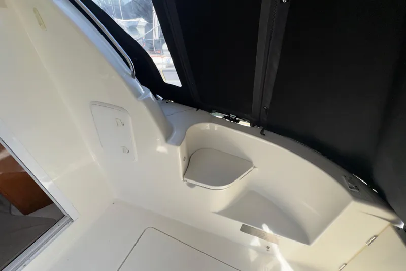 Slide: The Image of Interior view of a 2007 Meridian 411 Sedan boat, featuring sleek white seating. - 24