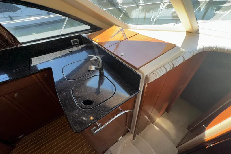 Slide: The Image of Interior of 2007 Meridian 411 Sedan yacht with sleek black countertop and wooden cabinetry. - 6