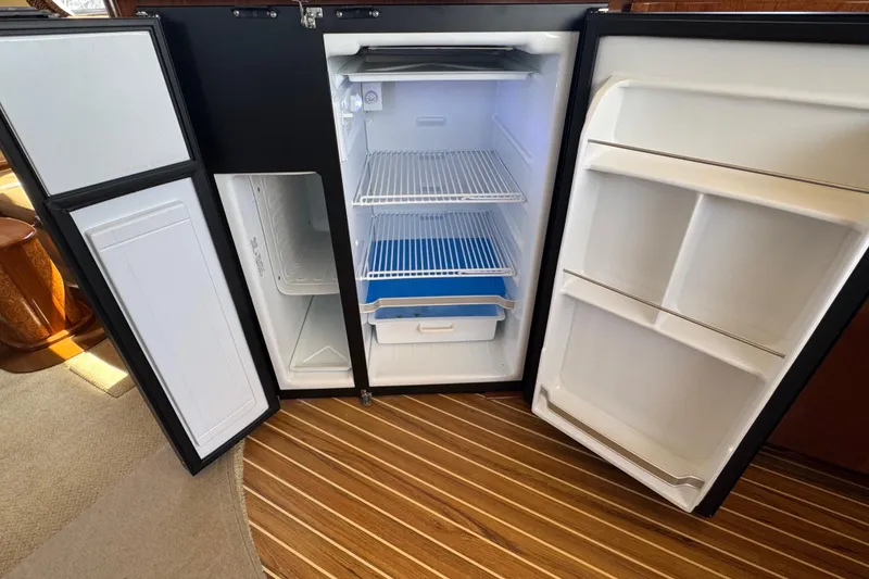 Slide: The Image of Open refrigerator in 2007 Meridian 411 Sedan yacht, showcasing spacious interior and shelving. - 64