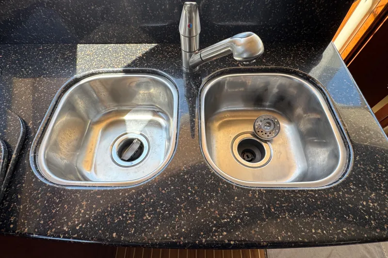 Slide: The Image of Stainless steel double sink with faucet on black speckled countertop in 2007 Meridian 411 Sedan. - 65