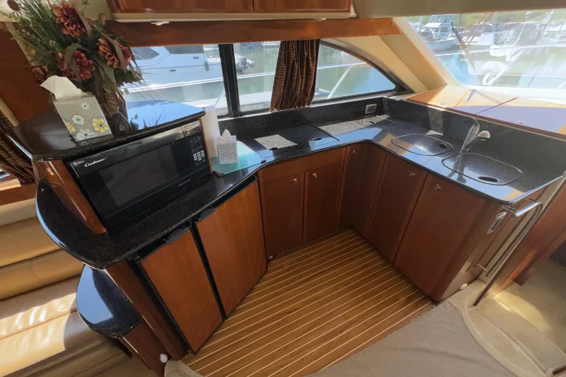 Slide: The Image of Luxurious 2007 Meridian 411 Sedan yacht kitchen with modern appliances and elegant wood cabinetry. - 7