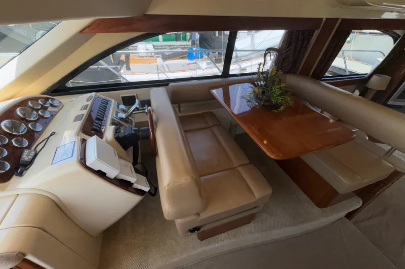 Slide: The Image of Luxurious interior of a 2007 Meridian 411 Sedan yacht with leather seating and wooden table. - 9