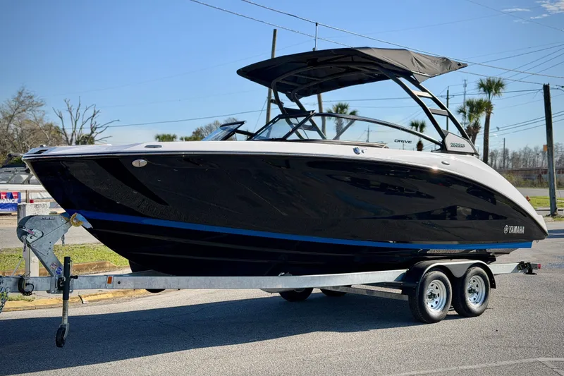 The Image of 2026 Yamaha Boats 252SD on trailer, sleek black design, parked outdoors. - 0