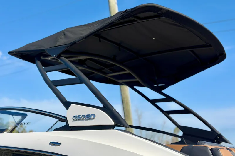 Slide: The Image of 2026 Yamaha Boats 252SD with sleek black canopy against blue sky. - 2