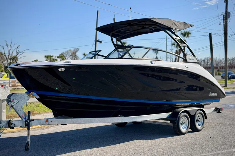 Slide: The Image of 2026 Yamaha Boats 252SD on trailer, sleek black design, parked outdoors. - 3