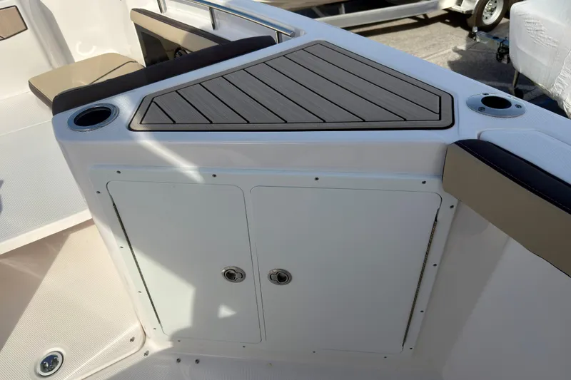 Slide: The Image of 2026 Yamaha Boats 255 FSH Sport H interior with storage compartment and cup holders. - 21
