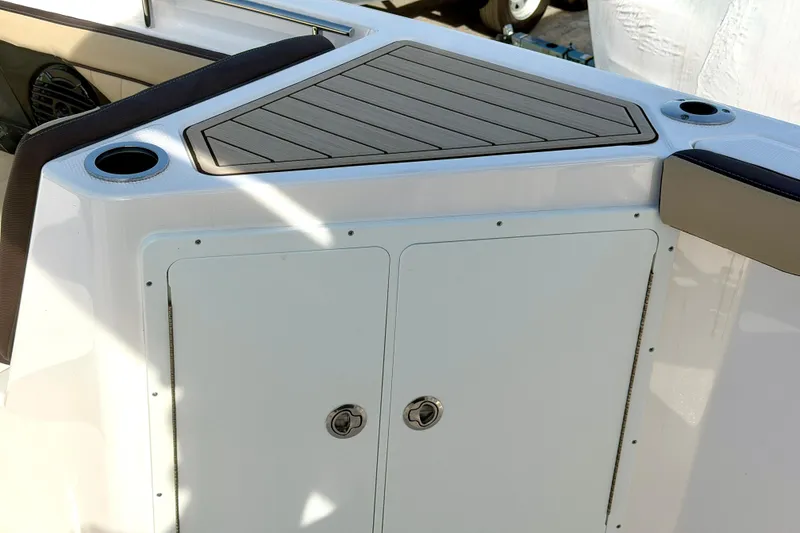 Slide: The Image of 2026 Yamaha Boats 255 FSH Sport H interior detail with storage compartment and cup holders. - 23