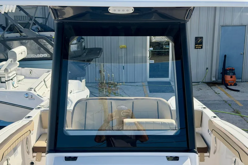 Slide: The Image of 2026 Yamaha Boats 255 FSH Sport H, interior view with seating and windshield. - 25