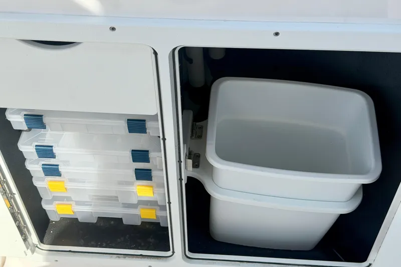 Slide: The Image of Storage compartments on a 2026 Yamaha Boats 255 FSH Sport H, featuring tackle boxes and bins. - 34
