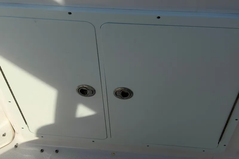 Slide: The Image of Storage compartment on 2026 Yamaha Boats 255 FSH Sport H, featuring dual latches. - 35