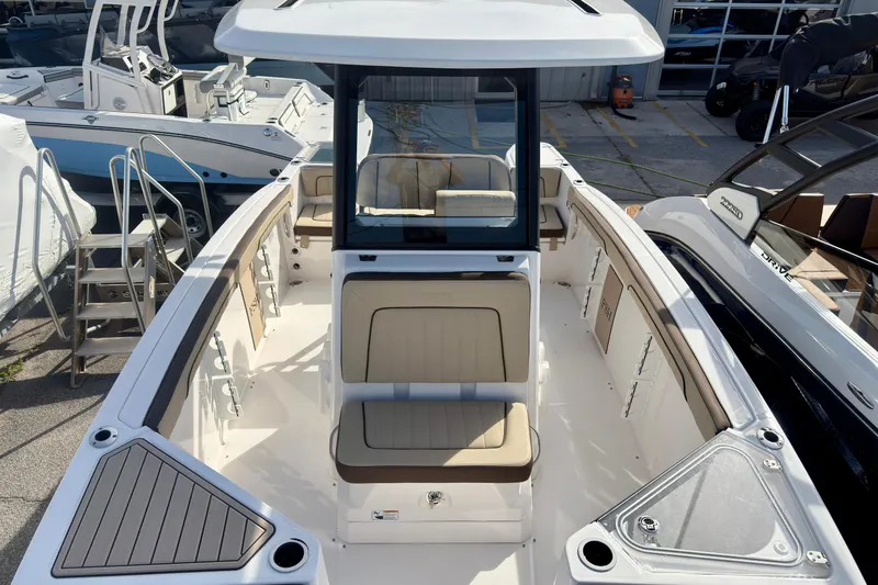 Slide: The Image of 2026 Yamaha Boats 255 FSH Sport H, spacious deck view, modern design, docked among other boats. - 38