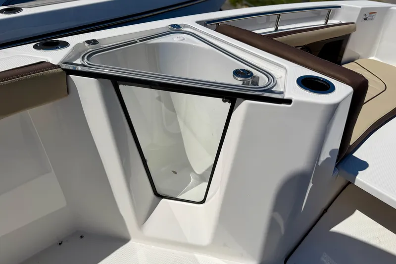 Slide: The Image of 2026 Yamaha Boats 255 FSH Sport H helm with rod holders, marina background. - 7