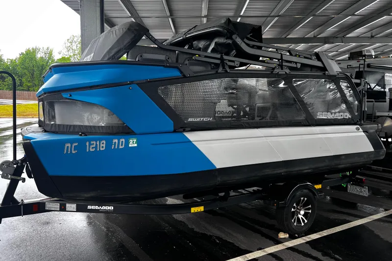 Slide: The Image of 2023 Sea-Doo Switch Cruise 18 boat on trailer, parked under shelter. - 10