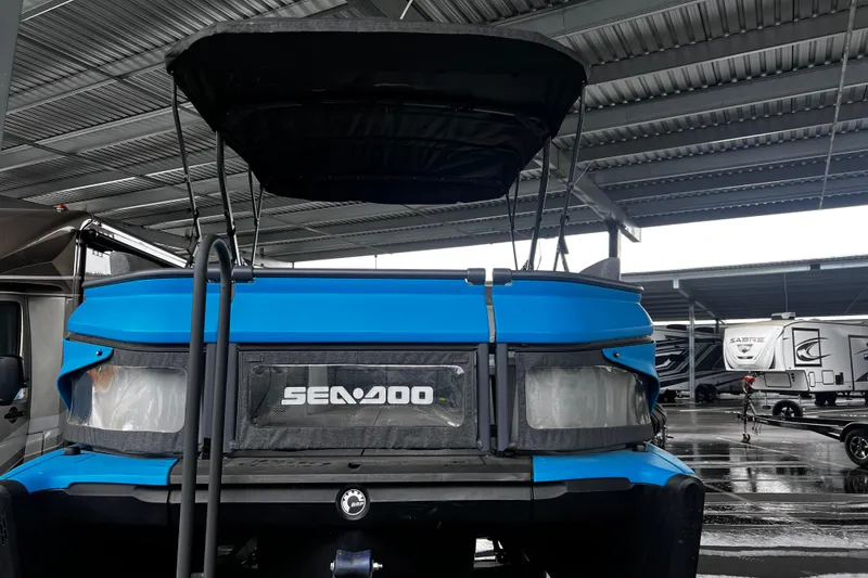 Slide: The Image of 2023 Sea-Doo Switch Cruise 18 under a metal canopy in a parking area. - 7