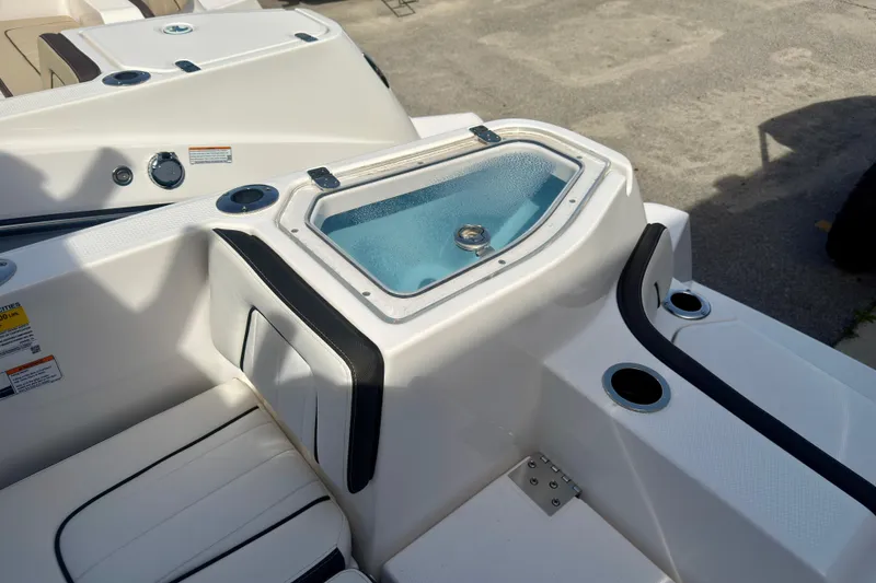 Slide: The Image of 2026 Yamaha Boats 255 FSH Sport H interior with seating and storage compartment. - 10
