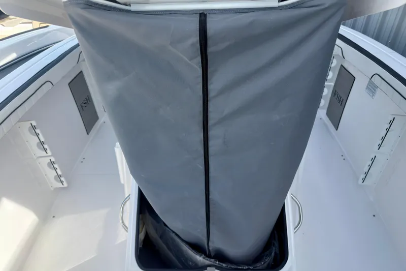 Slide: The Image of 2026 Yamaha Boats 255 FSH Sport H interior with storage compartment and cover. - 23