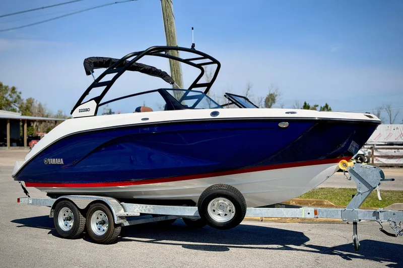 The Image of 2026 Yamaha Boats 222SD on trailer, blue and white design, parked outdoors. - 0