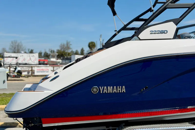 Slide: The Image of 2026 Yamaha Boats 222SD, sleek design, blue and white exterior, side view. - 2