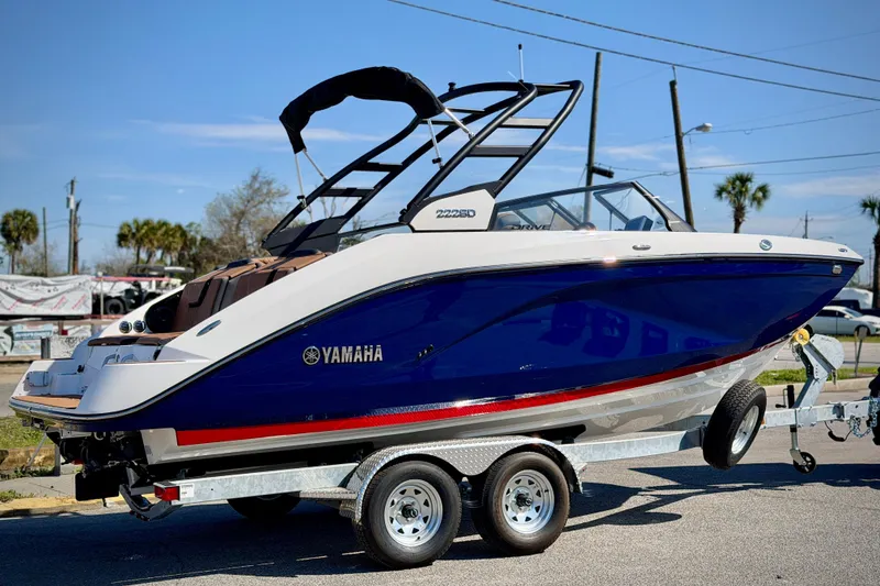 Slide: The Image of 2026 Yamaha Boats 222SD on trailer, blue and white design, parked outdoors. - 3