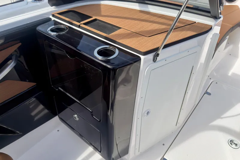 Slide: The Image of 2026 Yamaha Boats 222SD interior with sleek cabinetry and cup holders. - 34
