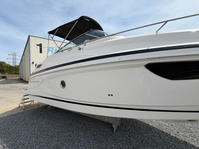 Slide: The Image of 2013 Regal 28 Express boat on gravel lot near warehouse. - 4