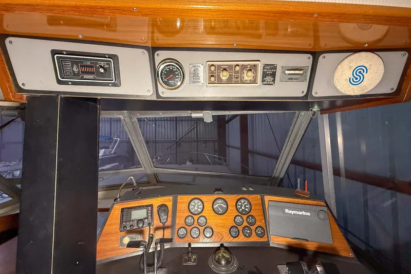 Slide: The Image of 1977 Pacemaker FB Motor Yacht dashboard with gauges and navigation equipment in a marina setting. - 10