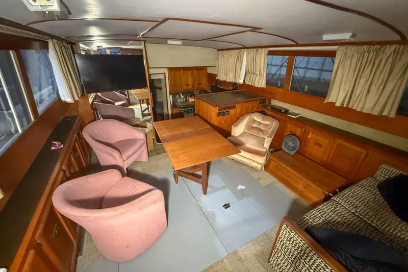 Slide: The Image of Interior of a 1977 Pacemaker FB Motor Yacht with wooden furnishings and pink chairs. - 24