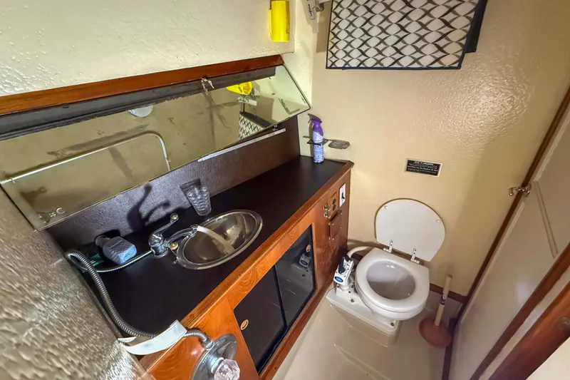 Slide: The Image of 1977 Pacemaker FB Motor Yacht bathroom with sink, mirror, and toilet. - 32
