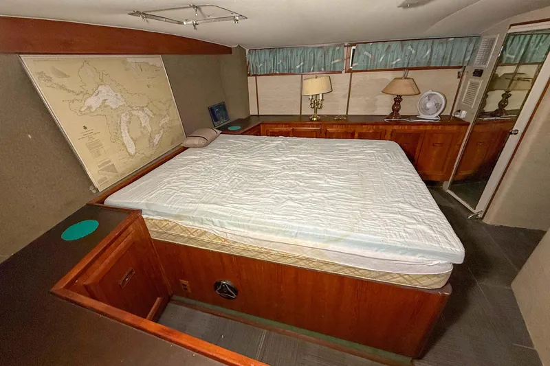 Slide: The Image of 1977 Pacemaker FB Motor Yacht cabin with bed, map, and wooden furnishings. - 37