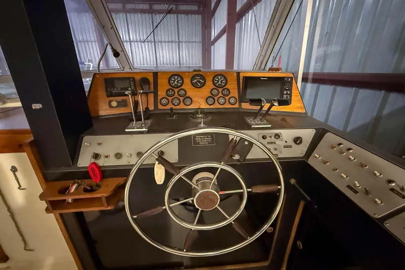 Slide: The Image of 1977 Pacemaker FB Motor Yacht helm with steering wheel, gauges, and navigation controls. - 9