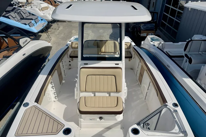 Slide: The Image of 2026 Yamaha Boats 252 FSH Sport with beige seating and sleek design in a showroom. - 17