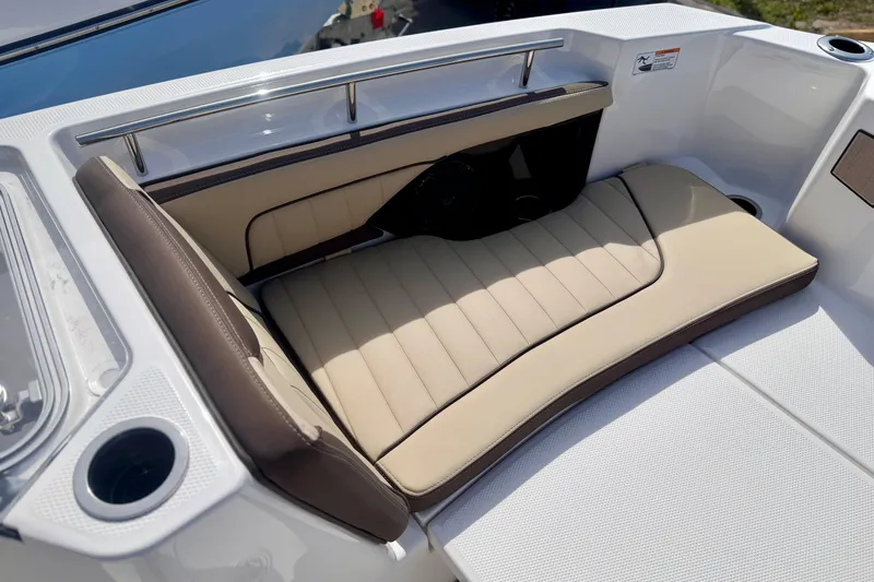 Slide: The Image of 2026 Yamaha Boats 252 FSH Sport interior seating with beige cushions and cup holder. - 30