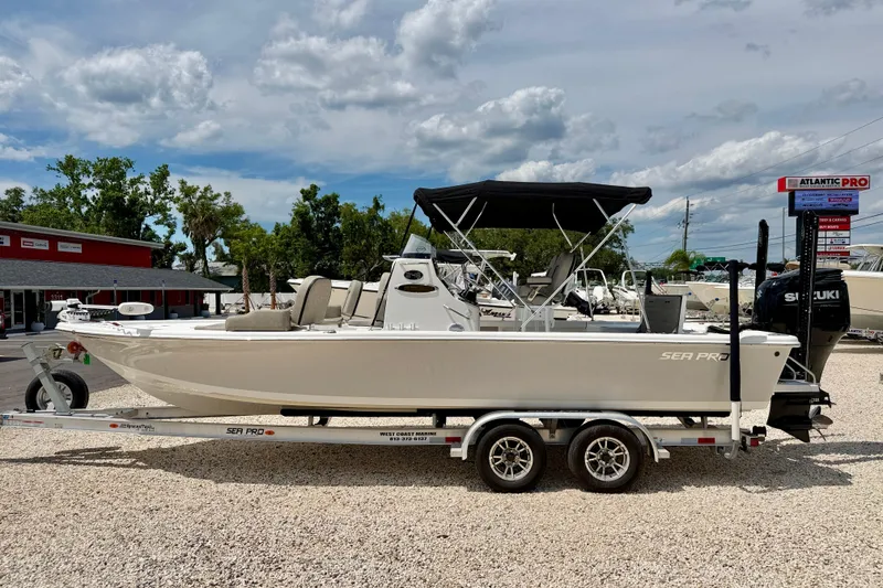 The Image of 2022 Sea Pro 248 Bay boat on trailer, parked outdoors under a cloudy sky. - 0