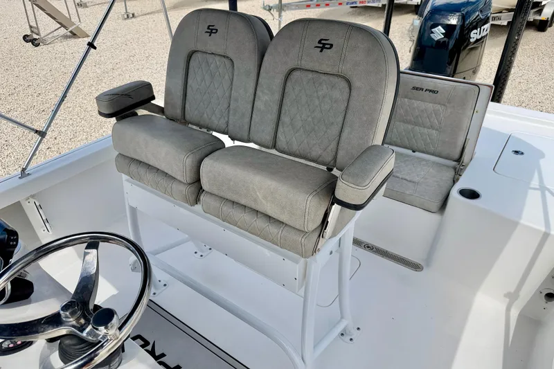 Slide: The Image of 2022 Sea Pro 248 Bay boat interior with dual seats and steering wheel. - 13
