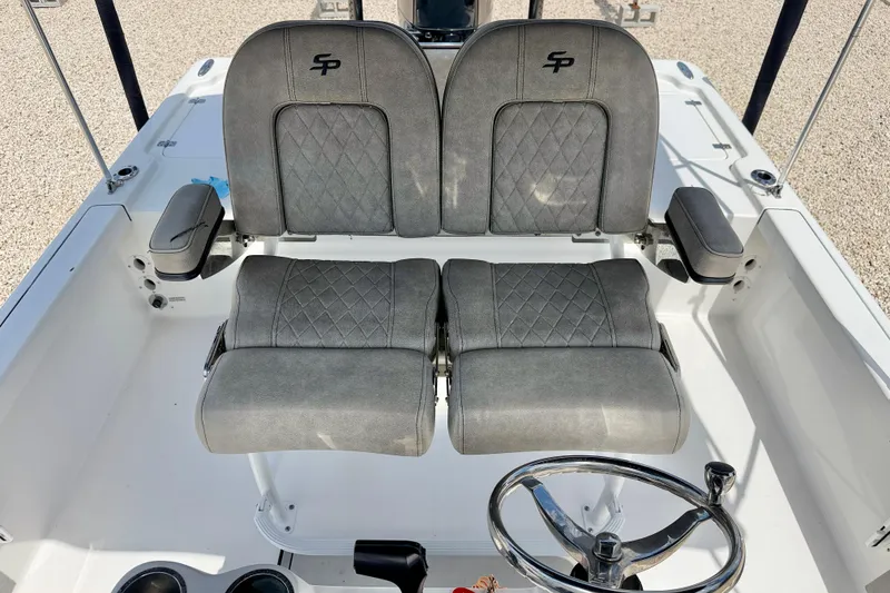 Slide: The Image of 2022 Sea Pro 248 Bay boat interior with dual gray seats and steering wheel. - 14
