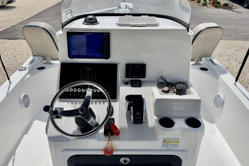 Slide: The Image of 2022 Sea Pro 248 Bay boat dashboard with steering wheel, navigation screen, and controls. - 15