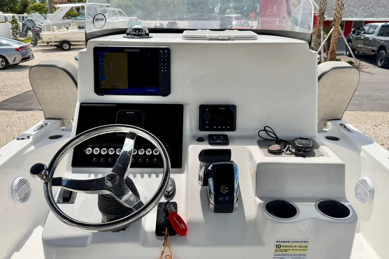 Slide: The Image of 2022 Sea Pro 248 Bay boat dashboard with steering wheel and navigation controls. - 16