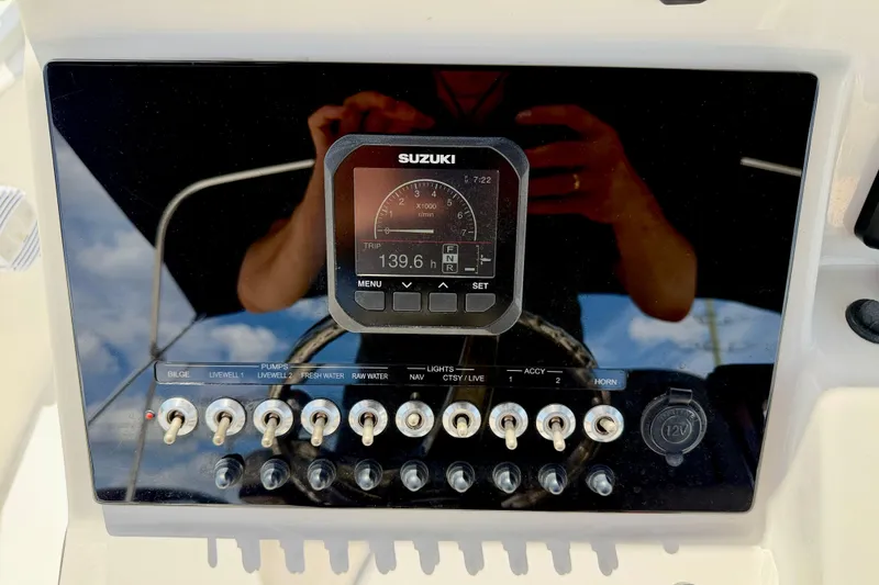 Slide: The Image of 2022 Sea Pro 248 Bay dashboard with Suzuki display and control switches. - 17