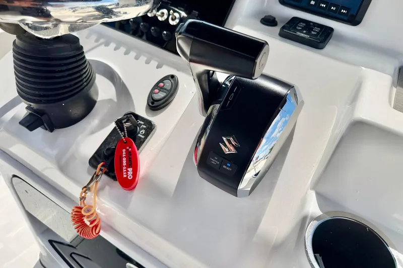 Slide: The Image of Control panel of 2022 Sea Pro 248 Bay boat with Suzuki throttle and keychain. - 19