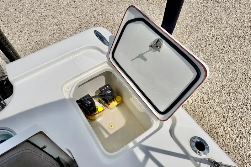 Slide: The Image of Open storage compartment on 2022 Sea Pro 248 Bay boat, revealing battery setup. - 27