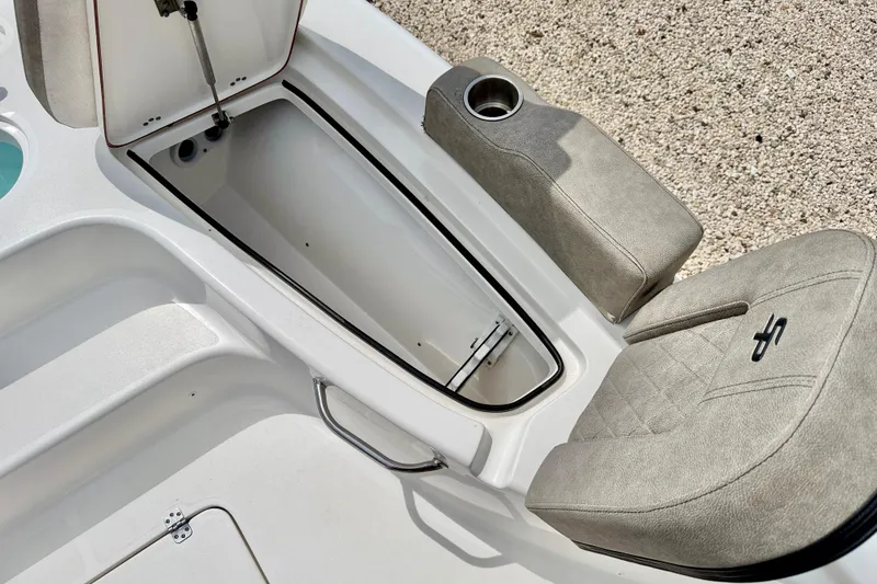 Slide: The Image of 2022 Sea Pro 248 Bay boat storage compartment with cushioned seating and cup holder. - 34
