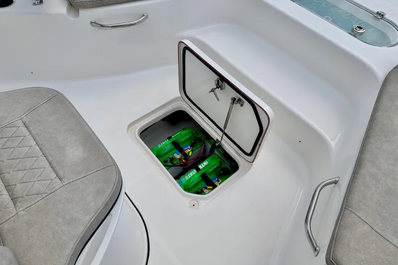 Slide: The Image of 2022 Sea Pro 248 Bay boat battery compartment with open hatch and visible batteries. - 39